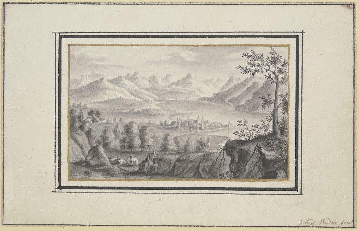 Blick auf einen See zwischen hohen Bergen und eine Stadt auf einer Landzunge im