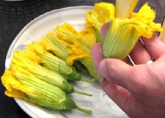 Rửa sạch hoa bí rồi cắt bỏ phần nhị hoa ở bên trong đi. Giờ thì nhồi cơm vào bên trong.