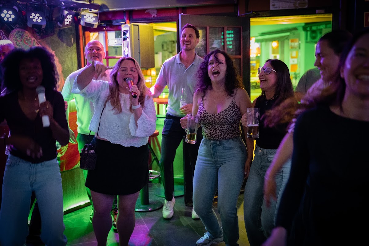 Guests singing karaoke together in a bar