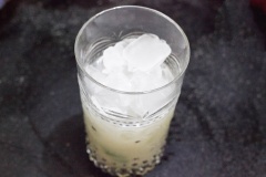 Đổ siro đường vào cốc, tiếp theo đổ nước cốt vải vào. Thêm 2-3 lá bạc hà vào cốc, đổ đá gần đầy miệng cốc. Cắt một lát cam để vào miệng thành cốc để trang trí, cho quả vải đã bỏ hạt còn lại vào đầy cốc.