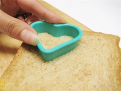 Dùng khuôn cắt bánh để cắt bánh mì thành hình trái tim nào! Bạn có thể dùng khuôn bánh in hoặc khuôn cắt rau củ được bán ở trong siêu thị cũng được. Cho bơ vào chén đun tan chảy bàng lò vi sóng.