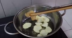 Đun nóng già 200ml dầu ăn, cho khoai tây vào chiên chín vàng giòn thì vớt ra để ráo dầu.