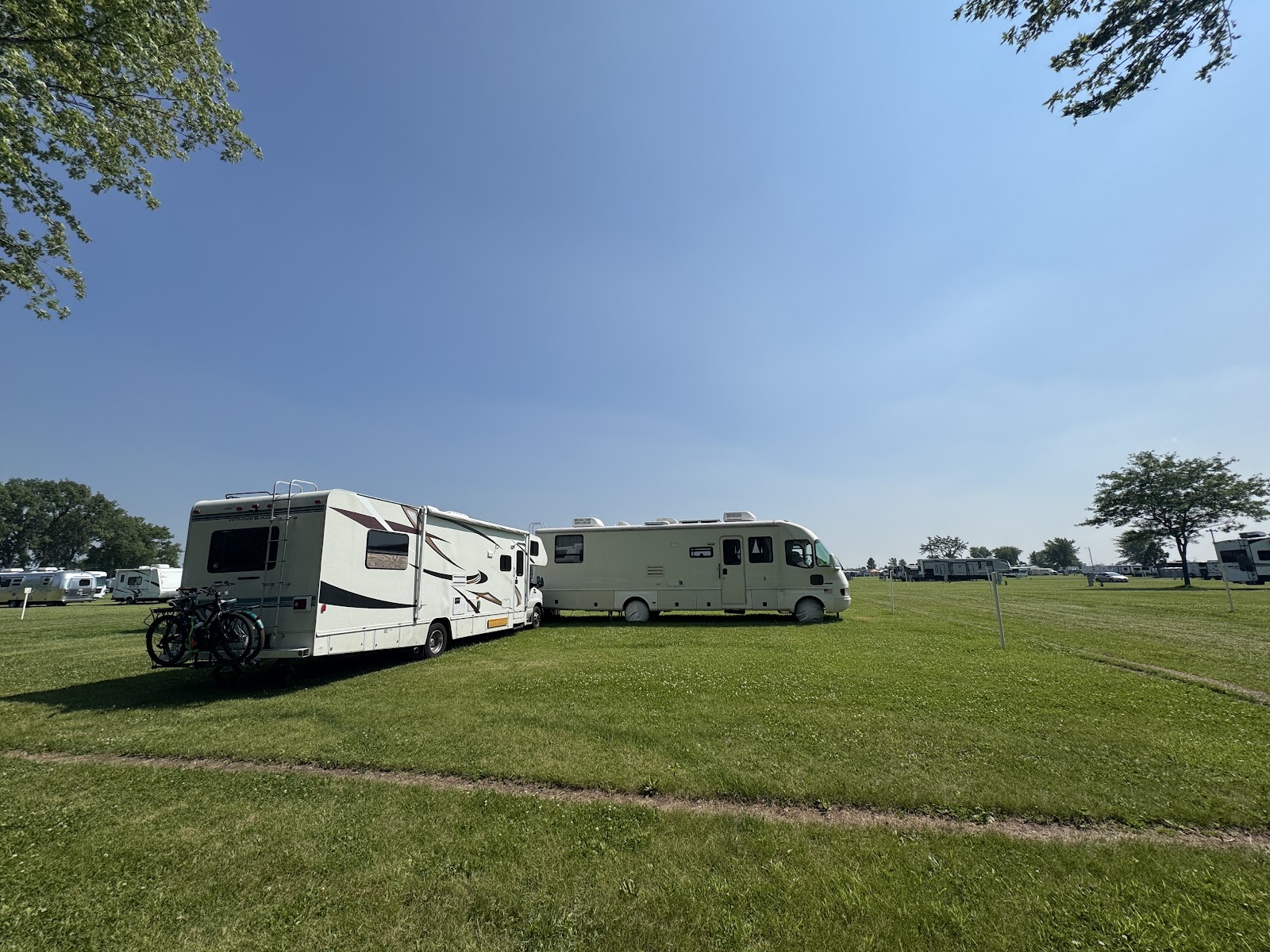 An RV parked and hooked up in the grass at Camp Scholler