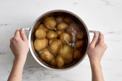 Khoai tây rửa sạch cho vào nồi, thêm 2 muỗng canh muối, chế nước ngâm mặt khoai rồi luộc chín. Sau đó vớt khoai ra ngâm vào nước lạnh cho nguội bớt rồi để ráo nước.