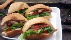 Rạch một đường ở giữa bánh mì, lần lượt xếp rau, dưa chuột, thịt xá xíu vào, rưới sốt xá xíu lên. Bánh mì nóng ăn với tương ớt rất ngon.