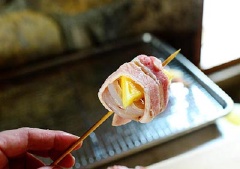 Thịt ba chỉ rửa sạch, cắt lát dài và mỏng. Dùng xiên tre xuyên qua tôm và dứa rồi bọc lớp thịt ba chỉ bên ngoài.