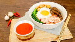 Cho mỳ ra tô, thêm thịt bò, tôm, cải thìa, tóp mỡ, trứng ốp la rồi rưới nước sốt lên là có thể thưởng thức rồi. Khi ăn xịt thêm tương ớt Chin-Su nữa để món ăn bùng vị hơn. Món mỳ trộn tóp mỡ ngon nhất là khi ăn nóng. Với vị cay nhè nhẹ, thơm thơm của nước sốt hoà quyện cùng thịt bò, tôm tươi chắc chắn bạn sẽ ăn mãi mà không ngán đấy.