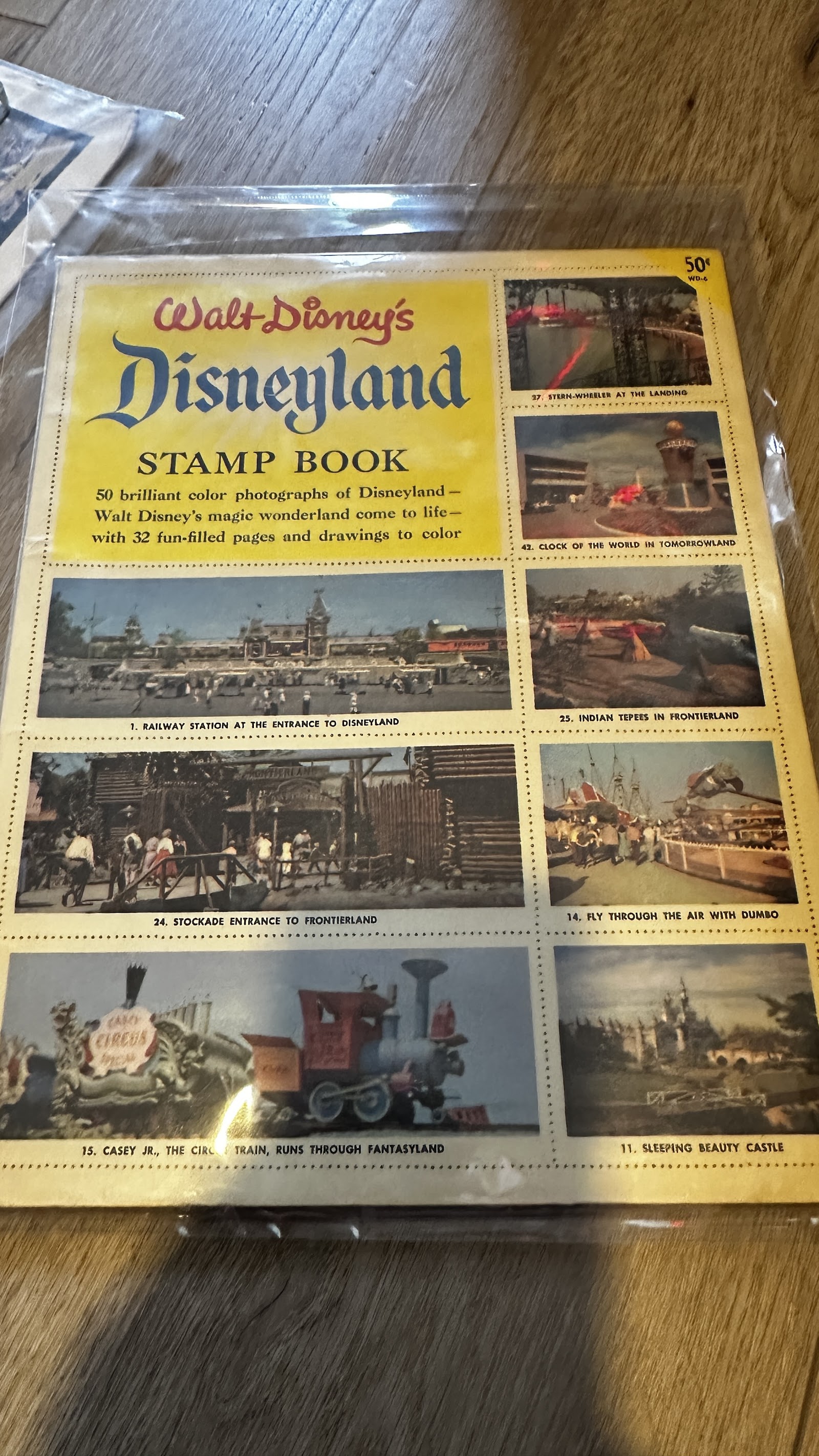Vintage Walt Disney's Disneyland stamp book with yellow cover featuring a grid of seven color photo stamps, circa 1957–1962, published by Western Printing
