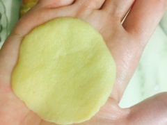 Cân vỏ bánh 12g và nhân bánh 10g. Vo tròn viên bột, dùng tay ấn dẹt, sau đó cho nhân vào giữa vào gói lại. Lót giấy chống đính và đặt bánh vào khuôn. Dùng dao tạo đường chéo trên mặt bánh.