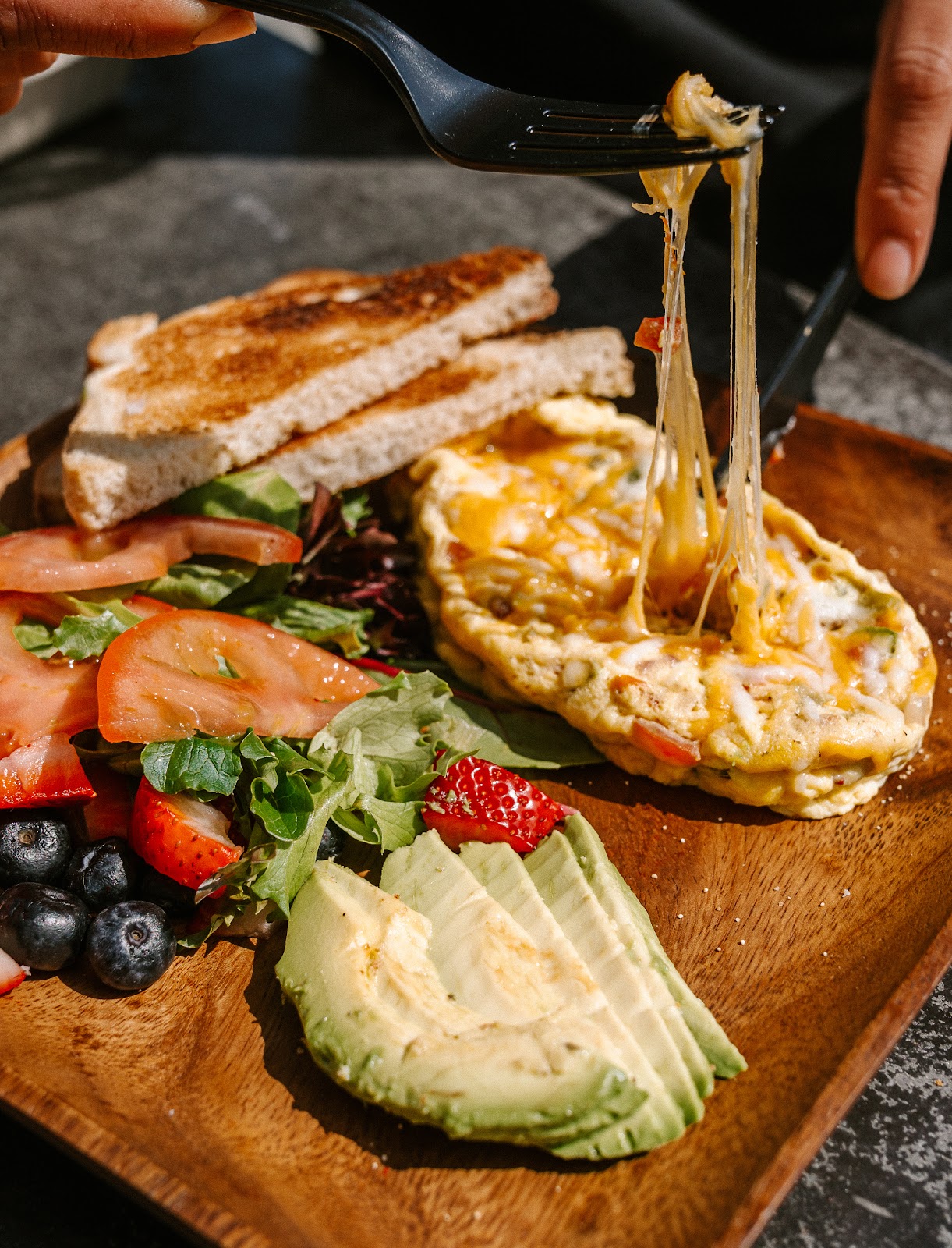 A beautiful breakfast plank with eggs, toast, and fruit