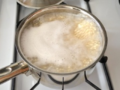 Đun sôi nồi nước, cho pasta couscous vào luộc tầm 5 - 7 phút đến khi chín mềm rồi trút ra rổ cho ráo nước. Dưa leo rửa sạch, cắt miếng nhỏ. Ngò xắt nhuyễn. Cho cả hai vào tô lớn với chút vỏ chanh bào. Nước sốt: cho nước cốt 1 trái chanh, 2 muỗng dầu olive, 1/4 muỗng bột tỏi, 1/4 muỗng muối, 1/4 muỗng tiêu vào chén và khuấy đều lên.