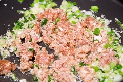 Làm nóng chảo với 2 muỗng canh dầu ăn. Phi thơm 2 muỗng cà phê tỏi băm, 1/2 hành lá cắt nhỏ rồi cho thịt heo bằm vào. Nêm 1 muỗng canh nước tương, 2 muỗng cà phê hạt nêm, trộn đều. Thịt chín sơ thì cho nấm mèo cắt sợi, 1 muỗng canh sốt sa tế, 1 muỗng canh đường và 1/2 chén nước vào, nấu sôi.