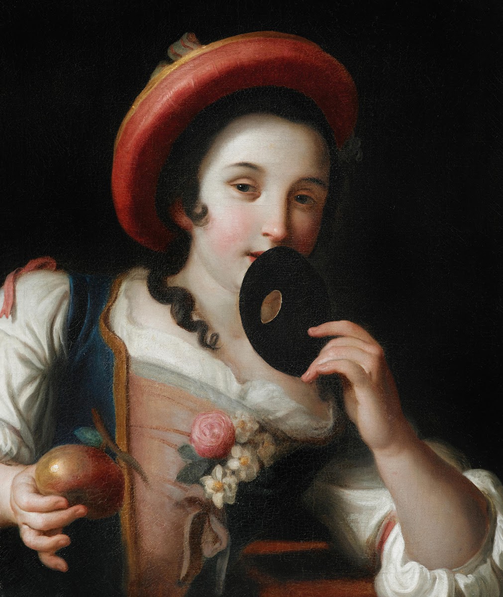 A young woman holding a mask and a pomegranate