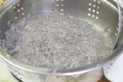 Mực rửa sạch, lột bỏ da. Miến ngâm nước khoảng 15 phút cho nở, sau đó chần qua nồi nước sôi, vớt miến ra xả qua nước lạnh để miến không bị dính chùm, để lên rổ cho ráo nước.