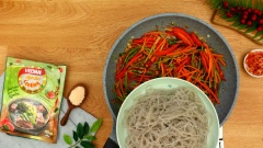 Cho miến đã trụng chín và tôm đã chiên vàng vào, đảo đều cho tất cả nguyên liệu ngon hơn.