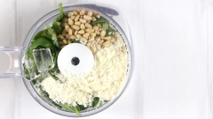 Lá húng quế rửa sạch, tỏi bóc vỏ. Cho 60gr lá húng quế, 30gr hạt thông và 30gr phô mai parmesan và 2 viên đá viên vào máy xay thực phẩm và xay nhuyễn hỗn hợp. Khi các thành phần đã nhuyễn, cho 50ml dầu olive, một chút muối và tiêu vào tiếp tục xay đến khi mịn mượt.