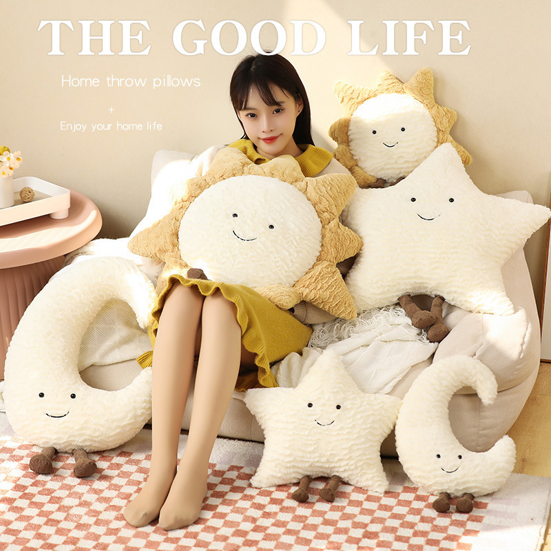 Decorative cuddle pillows with moon, star, and sun motif