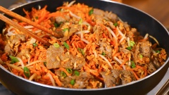 Sau đó cho cà rốt, giá lặt, thịt bò vừa xào vào chảo, nêm nếm vào 2 muỗng canh nước tương, trộn đều đến khi vừa chín là được.