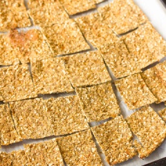 Bật lò trước 10 phút ở 200 độ C. Trải một tờ giấy nến lên mặt phẳng, múc hỗn hợp bông cải xay vào, đặt một tờ giấy nến khác lên trên và dùng chày cán hỗn hợp bông cải thành tấm thật mỏng. Gỡ bỏ giấy nến phía trên và đặt bông cải cùng giấy phía dưới vào khay nướng. Để khay bông cải vào lò và nướng từ 15- 20 phút, sau đó lấy ra, trở mặt snack lại và tiếp tục nướng thêm 15 - 20 phút đến khi có màu hơi vàng, giòn rụm là có thể lấy ra cắt thành miếng vuông nhỏ.