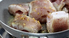 Phi thơm hành tỏi trên bếp rồi cho cá vào chiên sơ cho săn mặt. Sau đó cho 50gr nấm rơm vào đảo sơ qua khoảng 5 phút cho thơm.