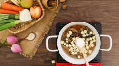 Cho vào nồi nước hầm bắp non, cà rốt và nấm đông cô, khuấy đều rồi đun sôi. Sau đó nêm vào nồi súp 1 muỗng canh đường phèn, 2 muỗng canh hạt nêm nấm hương Knorr rồi khuấy đều.