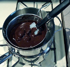 Cắt nhỏ chocolate đen, trộn với 125 ml dầu dừa rồi đem chưng cách thủy. Khuấy đều cho đến khi chocolate tan chảy hết thì tắt bếp để chocolate nguội.