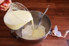 Rây vào thố trộn bột gồm: 135g bột mì, 30g đường bột, 3g muối nở (baking soda), 4 bột nở (baking powder), 3g muối. Sau đó, đổ hỗn hợp sữa bơ và trứng vào thố bột, dùng phới lồng khuấy cho quyện đều.