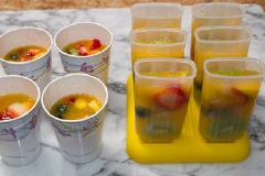 Thơm, đào, kiwi gọt vỏ, cắt hạt lựu. Việt quất và dâu tây rửa sạch, để ráo nước. Dâu tây chẻ làm đôi hoặc làm bốn. Cam cắt thành miếng nhỏ, bỏ vỏ. Cho tất cả các loại trái cây vào khuôn kem que, chế nước cam và nước thơm vào. Để kem trong ngăn đá cho đông lại khoảng 3 - 4 giờ là có thể lấy ra ăn được.