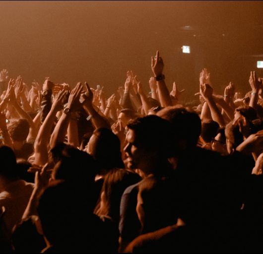 Foule en liesse sous une lumière cuivrée