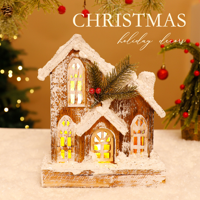 Beleuchtetes Weihnachts-Holzhaus mit Schneelandschaft