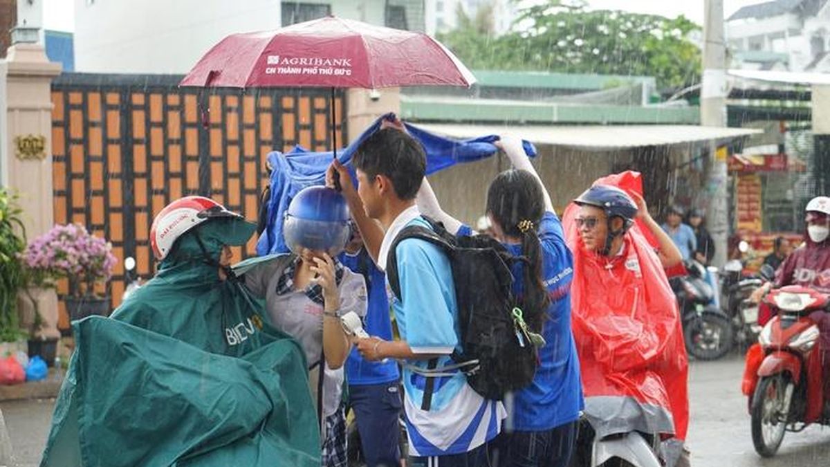 Mưa bất chợt, học sinh vẫn đội mưa tiếp sức thí sinh - Báo Người Lao Động