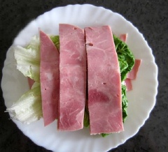 Xếp 1 lớp thịt nguội, 1 lớp trứng lên bánh mì sandwich. Sau đó đến xà lách và cuối cùng là thịt nguội.