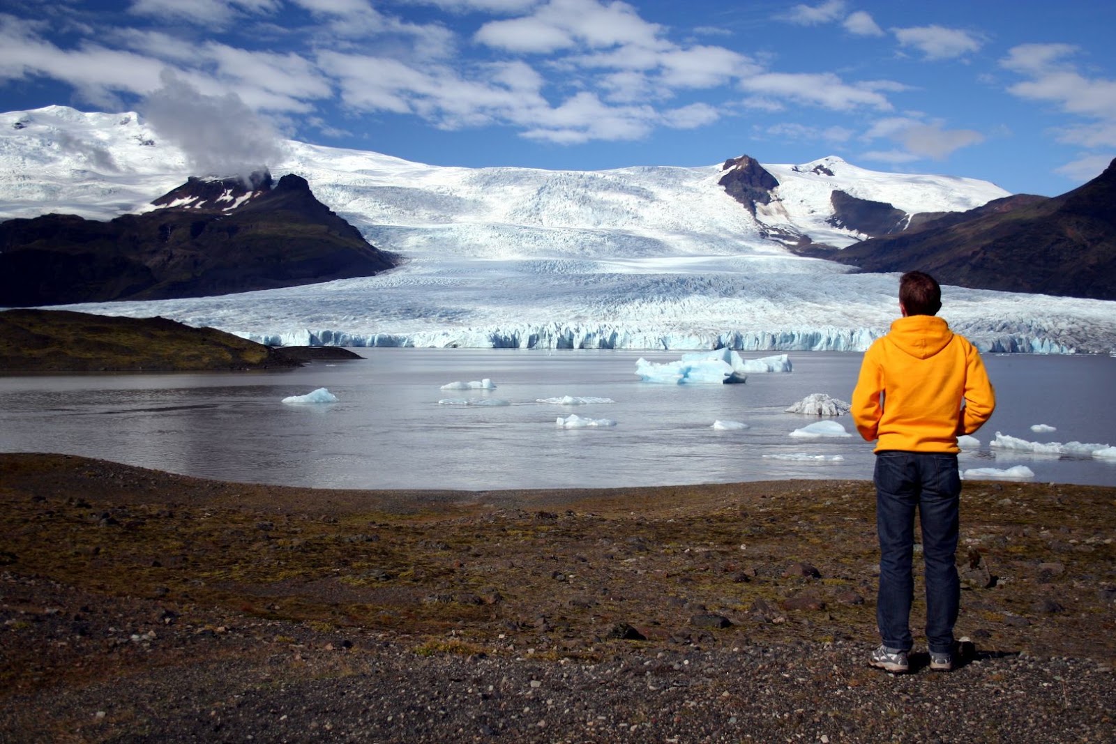 Traveler overlooking icebergs floating in Jökulsárlón Glacier Lagoon on Iceland’s south coast.