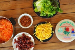 Chuẩn bị và sơ chế hết các nguyên liệu cần thiết, bạn bắt đầu cuốn bò bía. Trải miếng bánh tráng lên thớt (có thể thoa chút xíu nước hoặc không cũng được nha), cho ít trứng chiên, tôm khô, cà rốt và củ cải trắng bào sợi, một ít rau sống lên trên bánh tráng (xếp theo thứ tự như thế nào là tùy ý thích mỗi người). Cuốn bánh tráng lại thành cuộn tròn. Làm tiếp tục cho đến khi hết nguyên liệu bò bía mặn đã chuẩn bị.