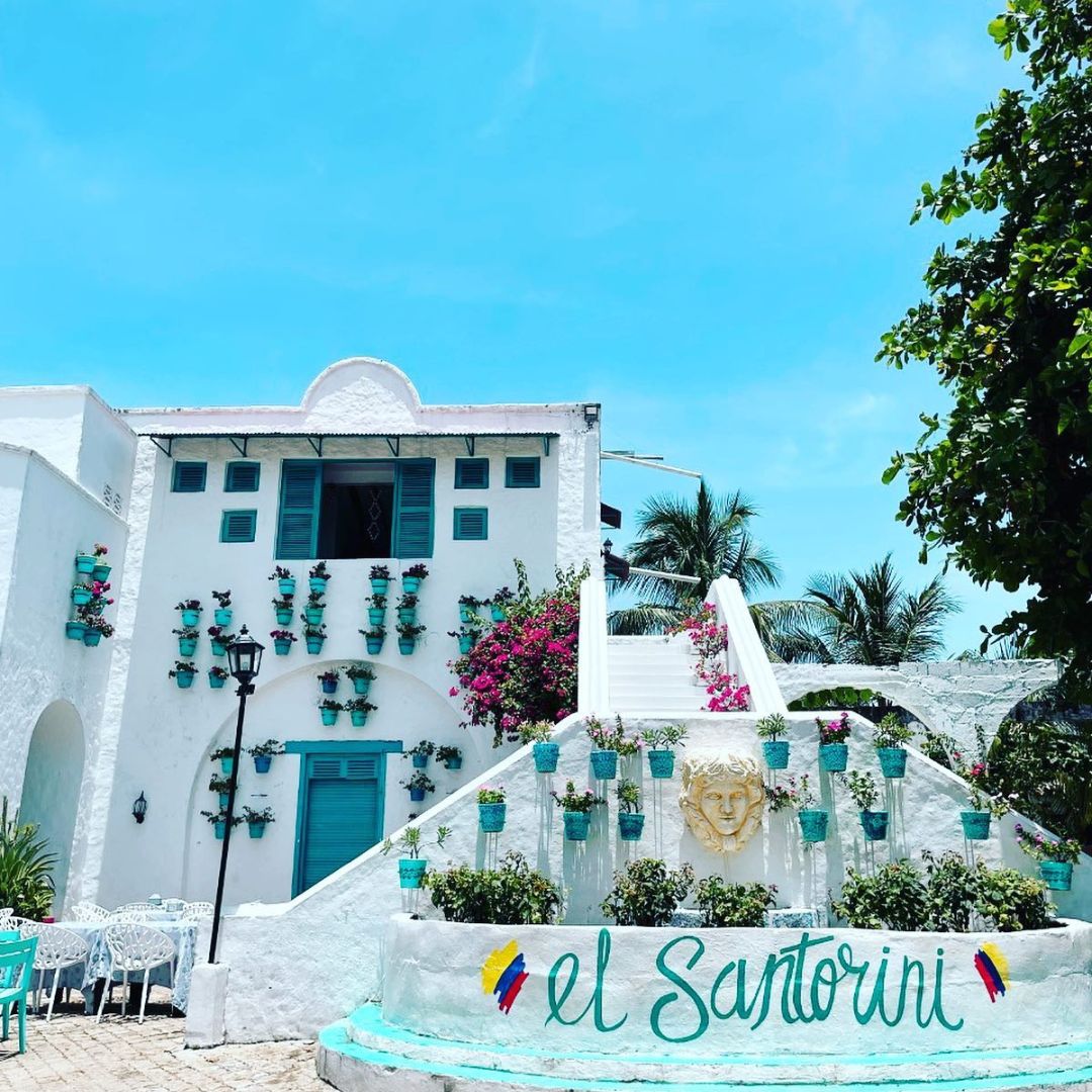 Fachada blanca de El Santorini en Barrio La Aldea, Doradal