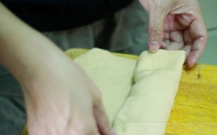 Chia bột làm 2 phần. Dàn mỏng bột ra, cuộn lại với chiều dài bằng khuôn bánh. Cho vào khuôn, đóng nắp lại. Ủ khoảng 45 phút. Lò làm nóng trước, nhiệt 190C.