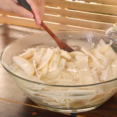 Đun sôi nước rồi cho vào tô măng đã cắt ngập phần mặt, thêm 1 muỗng canh muối chần sơ rồi đổ ra rổ cho ráo nước.