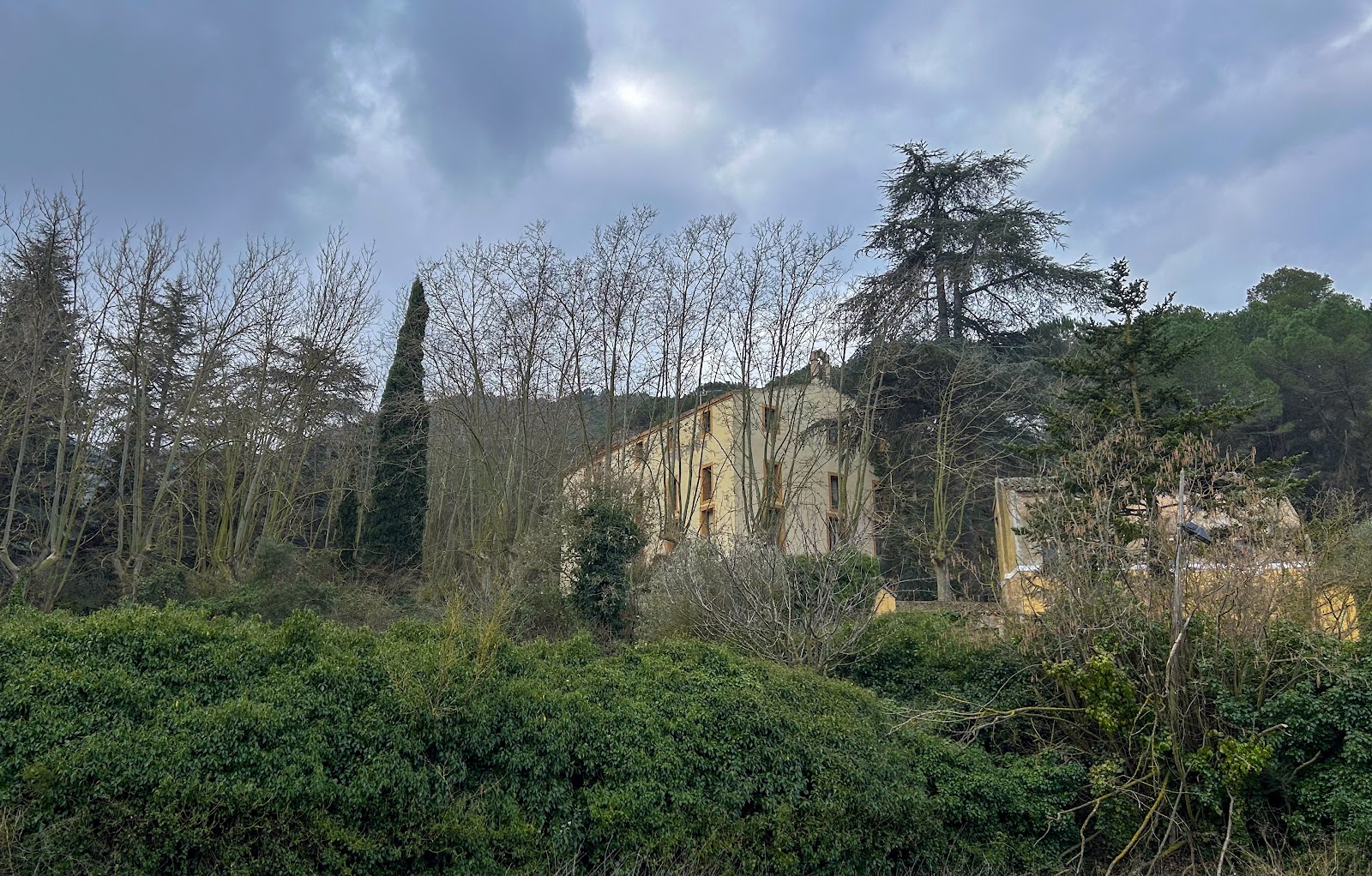 Wide view of the masia among trees and mountains