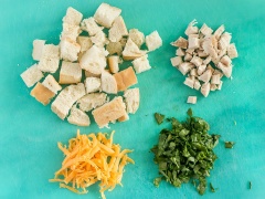 Bánh mì và thịt cắt khối vuông nhỏ. Cải bó xôi rửa sạch, cắt nhuyễn. Phô mai bào sợi. Bơ cho vào ly để vào lò vi sóng quay chảy rồi lấy ra. Trứng, sữa cho vào ly khác khuấy tan với muối, tiêu. Tiếp đó cho thịt, rau, phô mai, bánh mì vào ly bơ, chế trứng sữa vào và trộn đều lên. Đặt ly vào lò vi sóng quay 90 giây ở mức cao nhất là xong rồi đó. Khi lấy ly ra nhớ cẩn thận để không bị bỏng nhé.