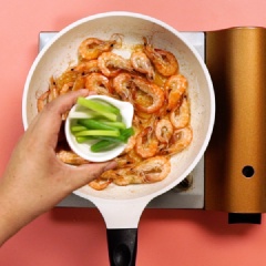 Làm nóng chảo, cho ít dầu ăn vào và tráng đều chảo. Khi dầu nóng thì cho tôm vào, đảo sơ đến khi tôm hơi chuyển cam thì cho 1gr muối, 3gr đường, 3gr nước tương, 5gr rượu trắng vào. Đảo đều đến khi tôm lên màu cam đỏ đẹp mắt, vỏ cháy giòn. Nếm thử xem tôm xào đã vừa chưa và nêm thêm gia vị nếu cần. Sau đó cho hành lá cắt khúc vào. Đảo nhanh tay đến khi hành chín thì tắt bếp.