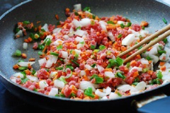 Đun nóng hai muỗng canh dầu. Sau đó cho hành tây, cà rốt, hành lá, thịt bò vào xào đến khi chín. Nêm nếm 1/2 muỗng cà phê muối, 1 muỗng canh nước tương, 1/2 muỗng cà phê tiêu vừa ăn.