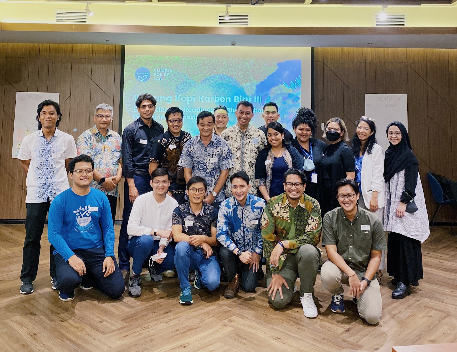 An event group photo with a mix of people wearing batik Blue Carbon Projects in Indonesia  with CarbonEthics’ Warung Kopi Karbon (Blue Carbon Ecosystem Conservation Indonesia)