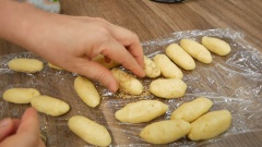 Đun nóng nhiều đầu ăn trong chảo sâu lòng (hoặc nồi nhỏ). Vê bột làm bánh đậu xanh kén thành khối trụ tròn dài. Sau đó chia nhỏ thành những phần đều nhau rồi vê thành kén. Lăn kén bánh đậu xanh qua mè cho áo đều rồi vê tiếp cho mè bám chắc vào bánh.