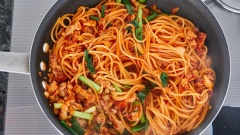 Cho dầu olive và tỏi băm vào chảo xào thơm. Đổ thịt ba chỉ vào xào cho đến khi thịt chín. Thêm kim chi đã thái nhỏ vào đảo chung. Đổ mì vào chảo thịt cùng với nước sốt kim chi, hành lá đảo đều và đun cho đến khi cạn nước thì cho mì ra đĩa, rắc chút phô mai bào lên trên.