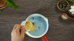 Làm rau câu hoa đậu biếc. Đun nóng 100ml sữa tươi trên bếp (không để sôi vì sữa sẽ đóng váng), thả hoa đậu biếc vào rồi tắt bếp. Chờ hoa đậu biếc tan ra màu xanh nước biển ưng ý thì chế thêm sữa đặc vào, khuấy đều cho hòa quyện. Cho 1/4 nước rau câu giòn lên bếp, đun sôi. Hạ lửa nhỏ cho 1.5gr bột rau câu dẻo jelly đã trộn 50gr đường trắng và 1/4 muỗng cà phê muối vào rồi khuấy đều. Đun cho hỗn hợp sôi lên rồi lại hạ nhỏ lửa, lọc nước sữa hoa đậu biếc (vớt bỏ phần hoa khô) vào nồi, khuấy đều. Giữ hỗn hợp nóng trên bếp đến khi dùng.