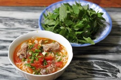 Cho bún vào tô, xếp các miếng sườn, cà chua, sấu lên trên, rắc thêm hành lá, húng quế lên trên mặt. Cuối cùng cho nước dùng vào là xong.