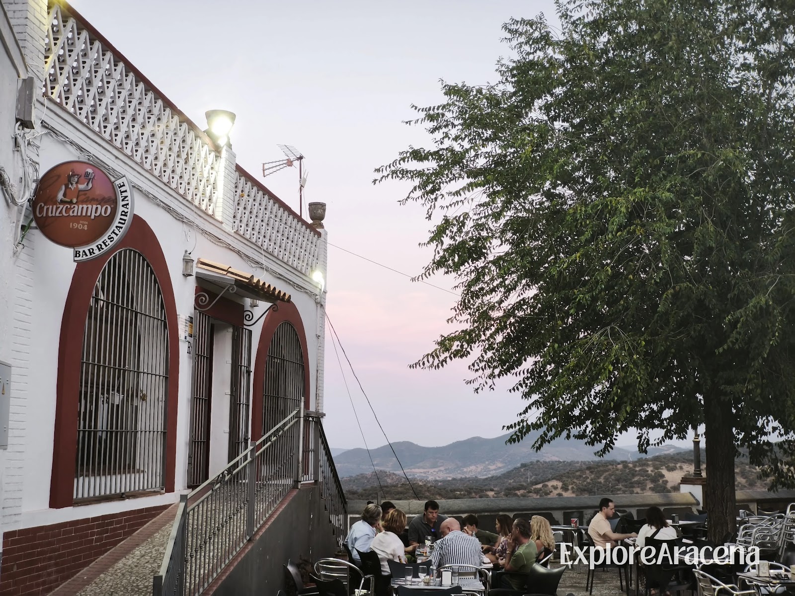 Restaurante El Mirador beside Zufre’s Paseo de los Alcaldes, with pink sunset colours across the sky.