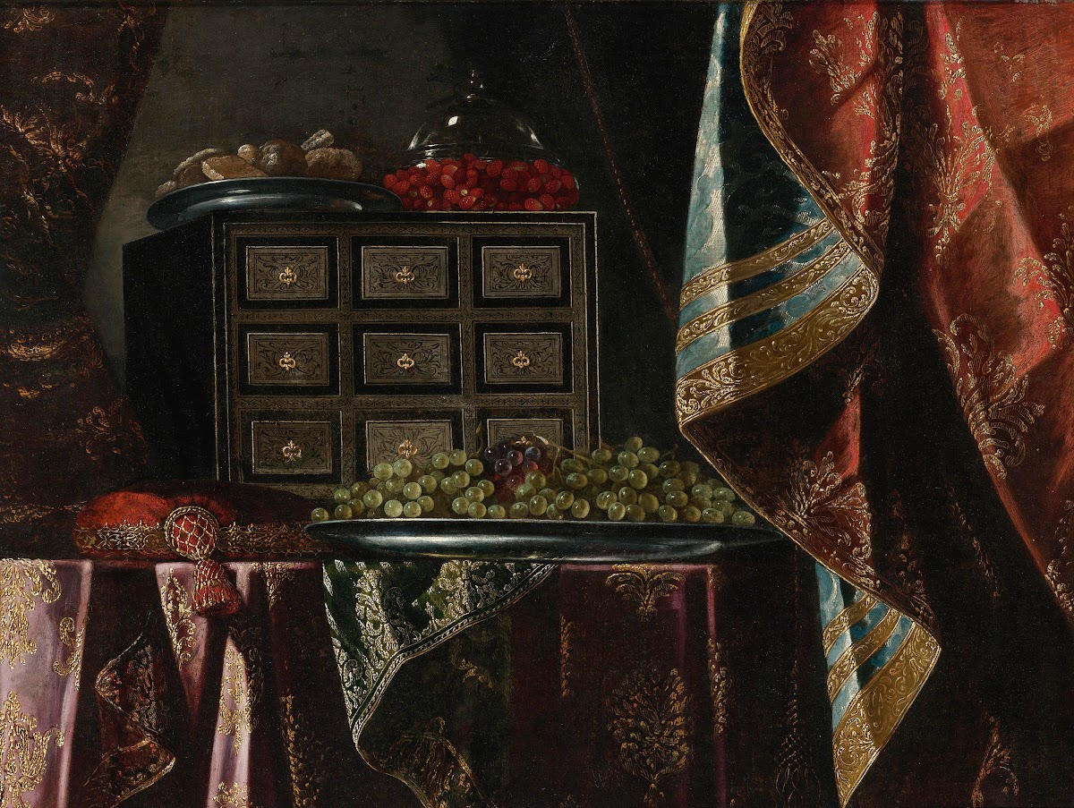 STILL LIFE OF A CHEST FRUIT AND OTHER OBJECTS ON A BROCADE DRAPED TABLE