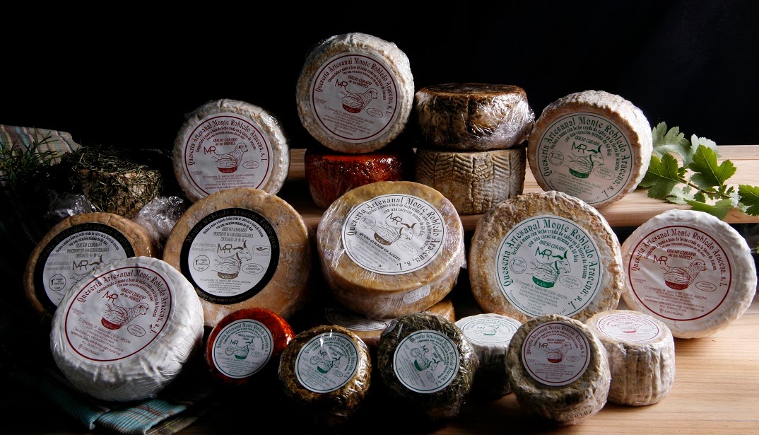 Wrapped Monte Robledo goat cheeses arranged together with their labels visible.