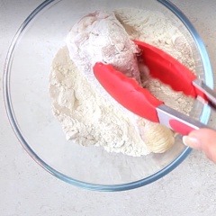 Mở lò nướng trước ở 200 độ C. Cho 60g bột mì vào âu cùng với chút muối và tiêu rồi trộn đều. Trong một tô khác, cho 120g bột chiên xù, 2 muỗng lá oregano khô, 2 muỗng bột tỏi, 2 muỗng ớt bộ paprika, 2 muỗng phô mai, chút tiêu và muối, trộn thật đều rồi cho vào túi zip. Trứng gà đập ra chén, đánh tan cùng sữa, chút muối. Thịt gà rửa sạch, để ráo nước, chặt miếng vừa ăn. Nhúng thịt gà qua bột mì.